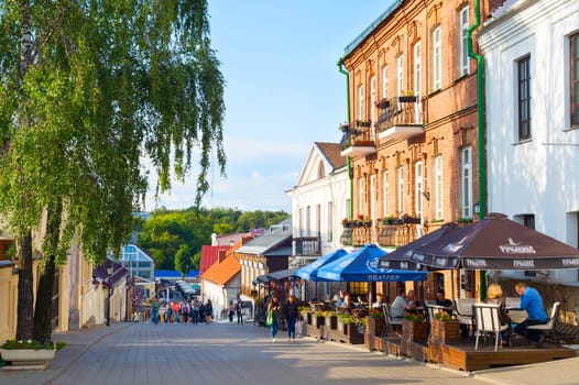 MINSK, BELARUS - JULY 19, 2019: People walking and sitting at restaurants on an Old Town street of Minsk.