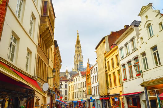 Touristic shopping street with cafes and restaurants, The Collegiate Church of Saints Peter and Guy view in background, Brussels, Belgium