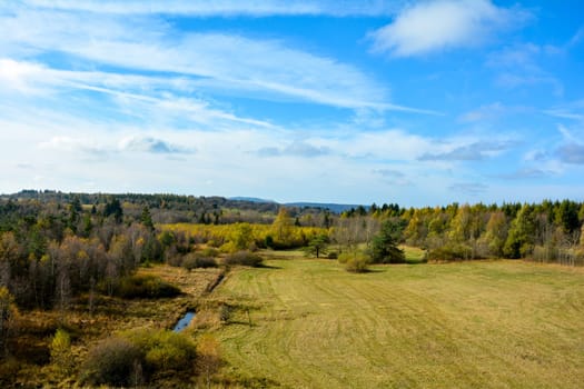 Green landscape from above, with big meadow, trees, water and blue sky in the Rhön, Bavaria, Germany, with copy space
