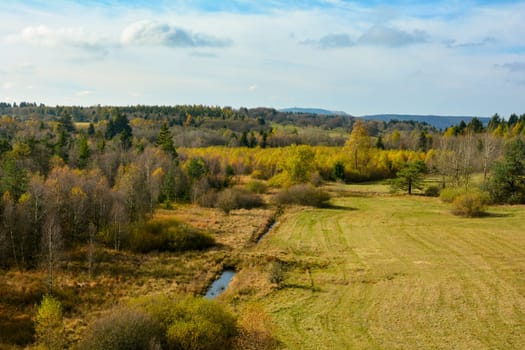 Green landscape from above, with big meadow, water, trees and blue sky in the Rhön, Bavaria, Germany