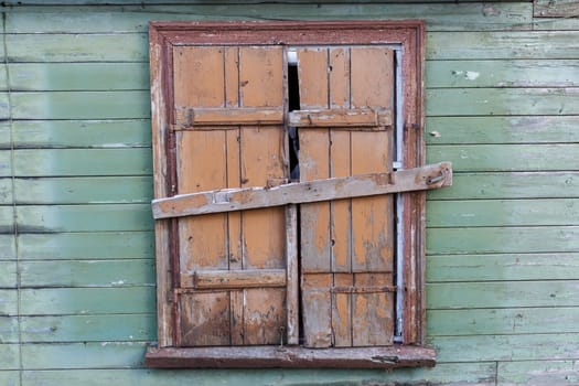 Window closed by wooden planks in an old abandoned building.