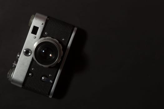 Retro film photo camera on black background