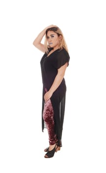 A lovely young woman standing in profile in black dress and .colorful tights under, isolated for white background.
