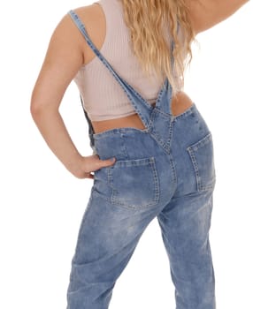 A gorgeous young woman standing from the back in working jeans and.with one hand on her hip, isolated for white background.