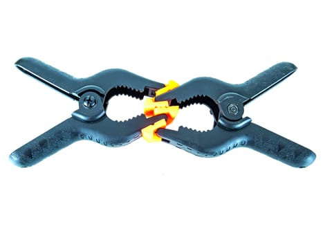 Construction tool black plastic clothespin on a white background. Place for text.