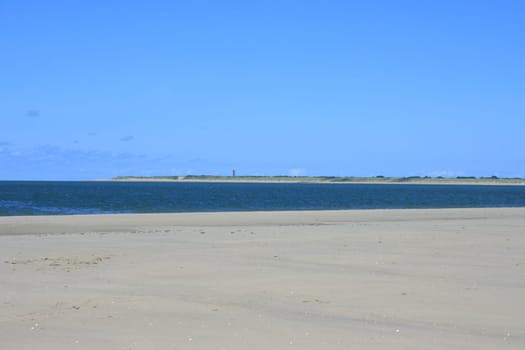Sandy beach with sea and blue sky background