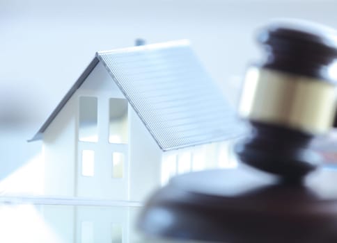 Close up Conceptual White Miniature House on Top of the Table Beside Court Gavel.