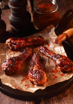 Four Saucy Barbecued Chicken Drumsticks on Cast Iron Pan