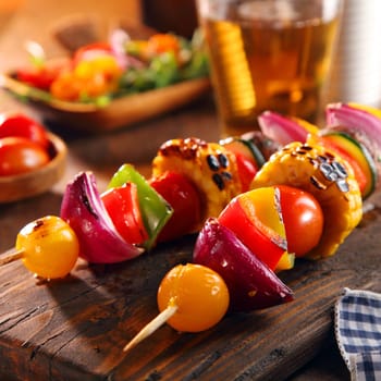 Roasted vegan vegetable skewers with cherry tomato, onion, sweet pepper, mushroom and corn on the cob in a colorful healthy nutritious assortment