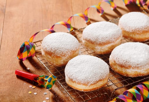 Close up Homemade Doughnuts with Powdered Sugar on Metal Screen, Placed on the Table at the Carnival.