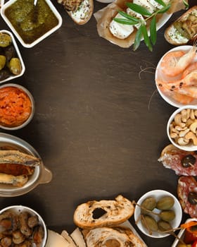 Conceptual Assorted Tasty Tapas on Brown Table with Copy Space at Center