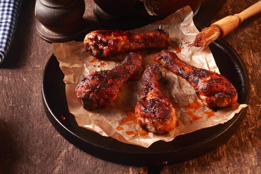 Four Saucy Barbecued Chicken Drumsticks on Cast Iron Pan