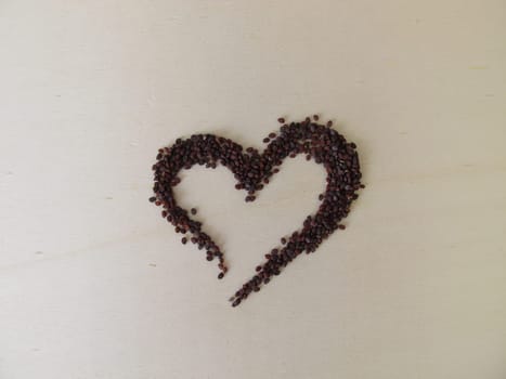 Edible brown-black seeds from wild field pennycress on a wooden board