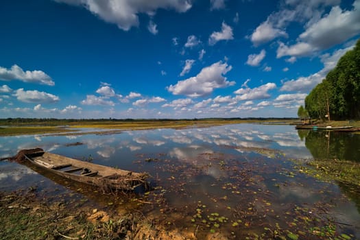Lake With Reflection, landscape with fishing boat and cumulus clouds