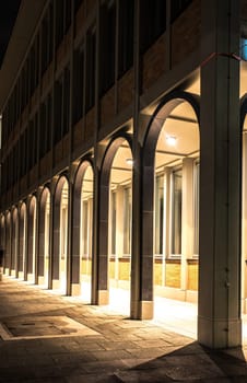Curved arcade of a multi-storey house at night with lighting