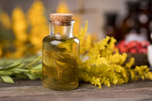 Fresh herbs and oils, wooden table background