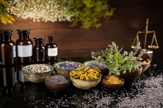 Alternative health, fresh herbal and mortar in black mirror background
