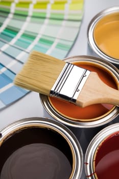Metal tin cans with color paint and paintbrush