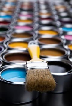 Paintbrush on cans with color