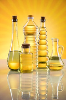 Olive oil, rapeseed oil, sunflower oil on sunburst orange background