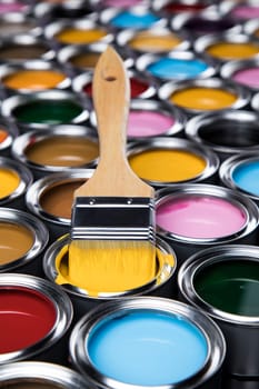 Paintbrush on cans with color