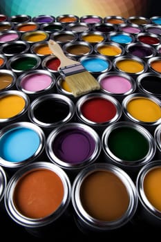 Paintbrush on cans with color