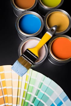 Metal tin cans with color paint and paintbrush