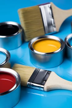 Metal tin cans with color paint and paintbrush