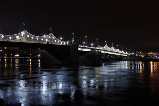 Drawbridge across the Neva River with illumination in St. Petersburg at night