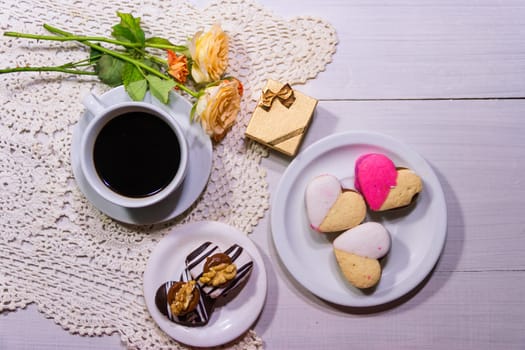 romantic flowers with coffee and sweet treats on the table