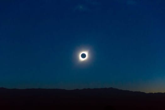 landscape with total eclipse of the sun over the mountains