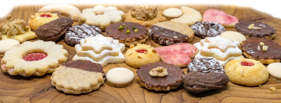 colorful mix of homemade christmas cookies on a dark wooden board