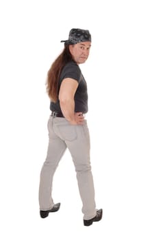 A serious looking middle age man in a black shirt standing with from.the back, with a head scarf, isolated for white background.