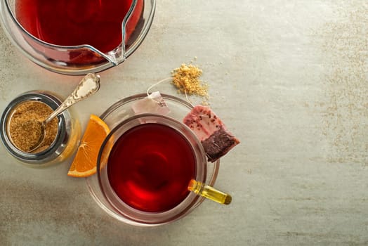 Cup of tea with sugar and teapot on grey table background