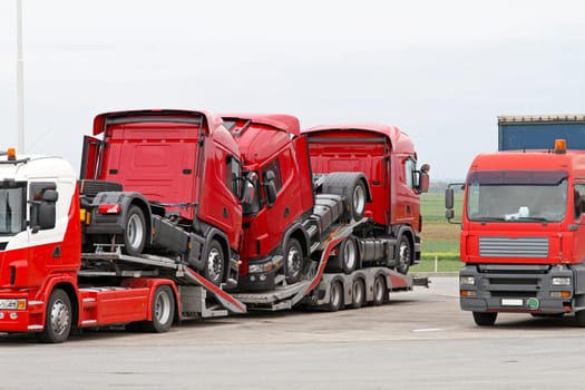 Transporting new red semi trucks at lorry