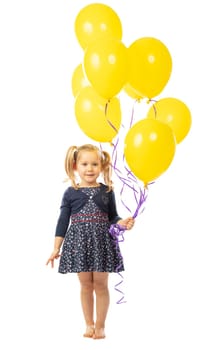 portrait of a smiling blonde 3 year old girl holding a group of yellow balloons. isolated on white