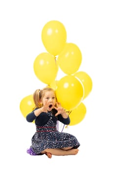 little girl sitting with balloons, playful and surprised expression. isolated on white background. childhood concept.