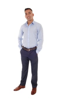 A handsome young east Indian man standing in a blue shirt with his.hands in his pocket, smiling, isolated for white background.