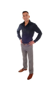 A handsome young east Indian man standing in a black shirt with his.hands on his hips, smiling, isolated for white background.
