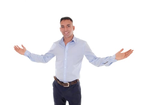 A handsome young east Indian man standing in a blue shirt with his.arms wide open, welcome everybody, isolated for white background.