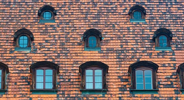 Tiled house roof with window in Wroclaw, Poland. Old town architecture of Europe.