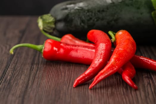 Red hot chili peppers on old wooden table.