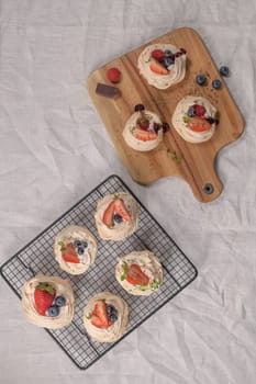 Small pavlova cakes with fresh raspberries and blueberries.