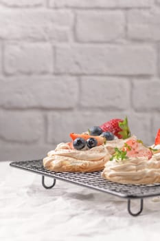 Small pavlova cakes with fresh raspberries and blueberries.
