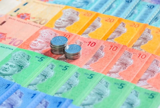 Malaysia currency of Malaysian ringgit banknotes and coins background. Sen coins of fIve and ten on paper money of one, five, ten, twenty and fifty ringgit notes. Financial concept.