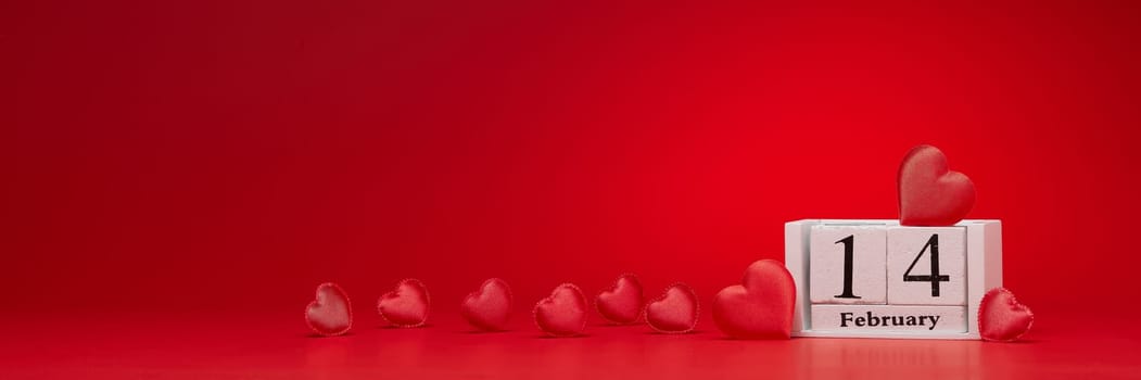 Group of silk red hearts, calendar with date 14 february on red background. Valentine's Day card with copy space. Design element for romantic greeting card, invitation. Hearts background.