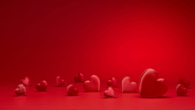 Valentine background with red silk hearts. Valentine's Day card with copy space. Design element for romantic greeting card, invitation. Women's Day. Hearts background. Wedding day. Selective focus