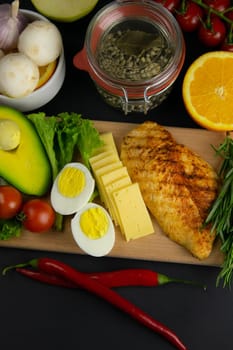 Ketogenic diet concept. A set of products of the low carb keto diet. Green vegetables, nuts, chicken fillet, flax seeds, quail eggs, cherry tomatoes. Healthy food concept. Keto diet food.