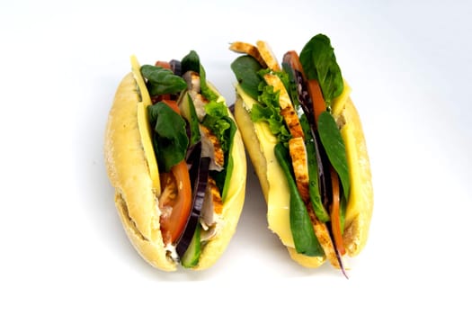 Italian ciabatta panini sandwich with chicken, cheese, tomatoes, avocado, lettuce. Isolated on white background