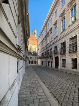 Historic Vienna, cobblestone street called Metastasiogasse with Minoritenkirche